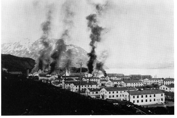 Buildings burn following first enemy attack on Dutch Harbor, 3 June 1942.